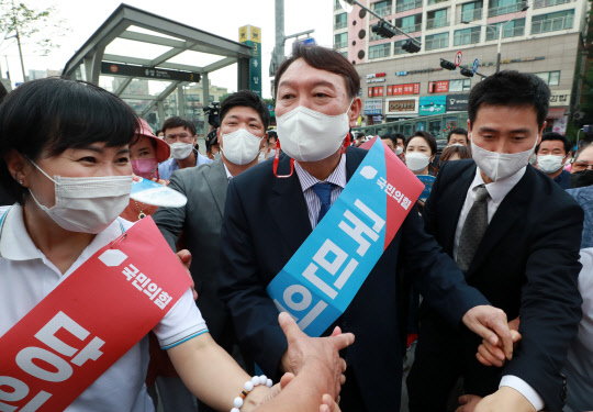 윤석열(가운데) 국민의힘 대선 예비후보가 3일 오후 서울 은평구 응암역 앞에서 국민의힘 당원 가입을 독려하는 홍보 활동을 위해 이동하며 지지자들과 악수하고 있다.연합뉴스·국회사진기자단
